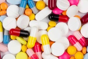 Pessoa com expressão de ansiedade ao olhar para medicamentos, simbolizando a farmacofobia.